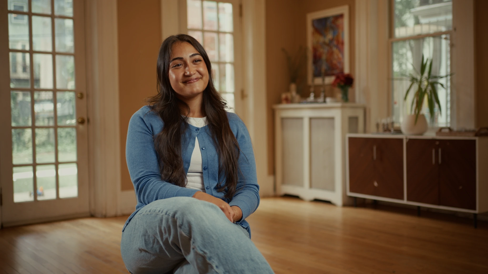 A seated interview beside tall windows in a warmly lit room