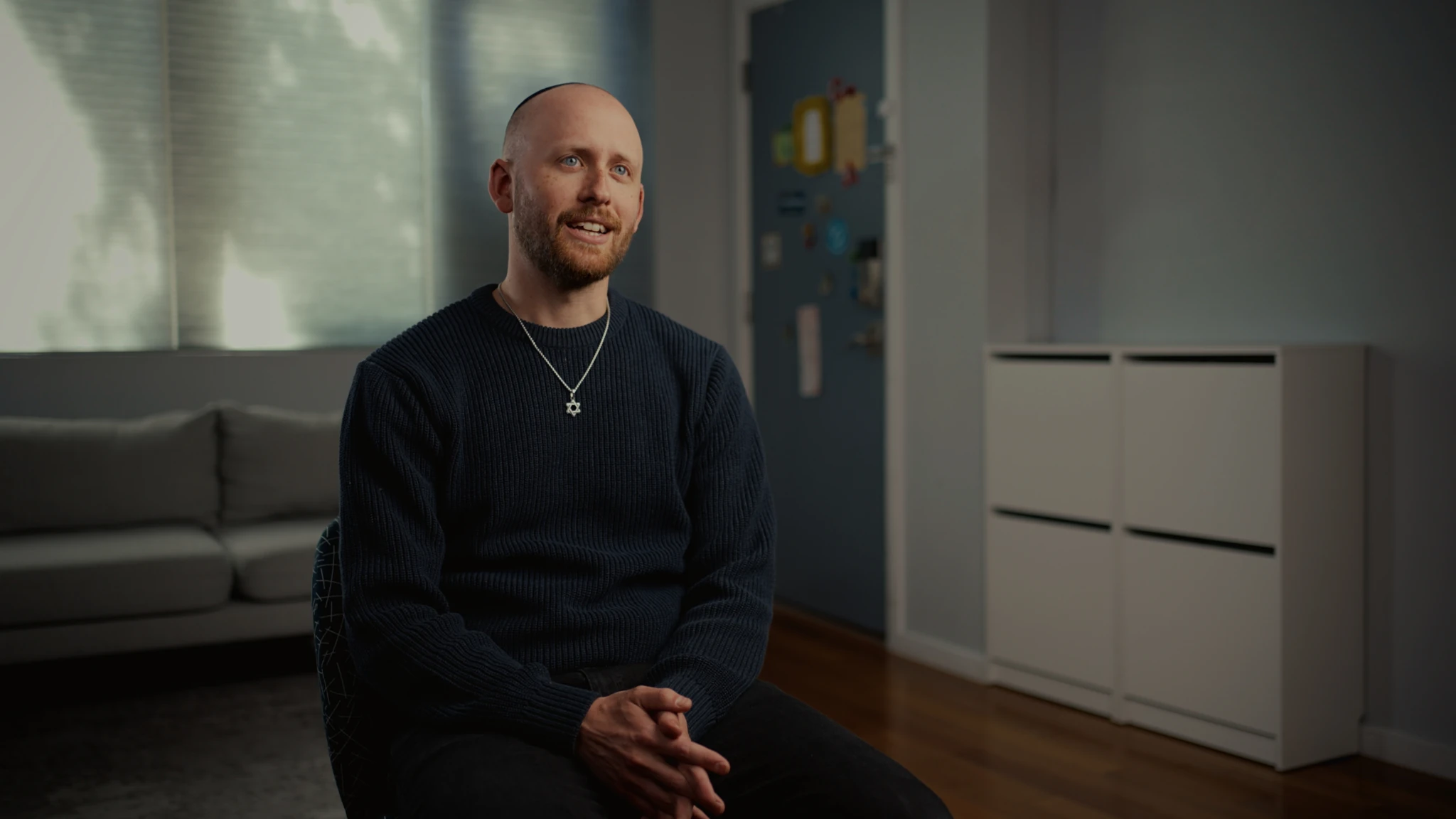 A seated interview in a softly lit blue room